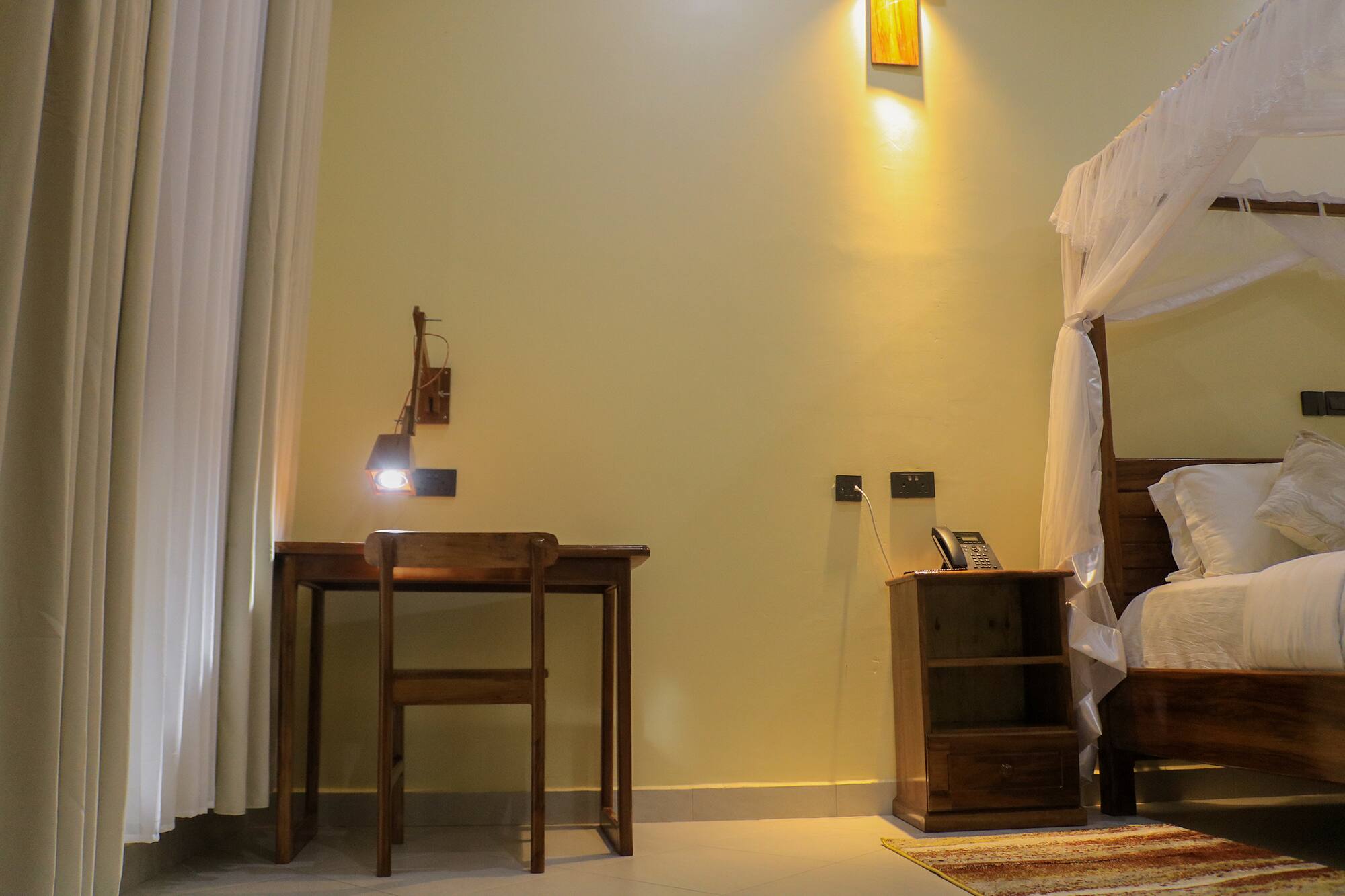 The Residence suite at Hati, with a writing desk beside the bed